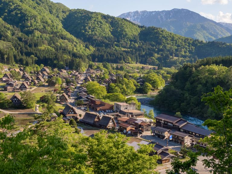 Explore the picturesque landscape of Shirakawa-go, a UNESCO World Heritage site in Japan, with traditional thatched-roof houses.