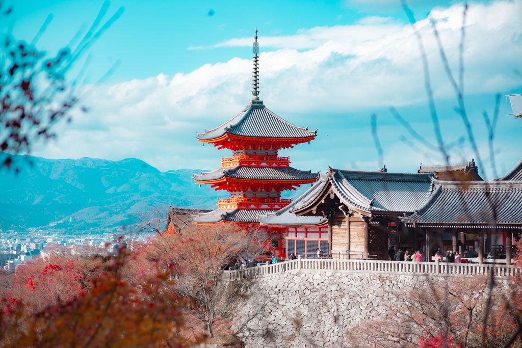 Stunning view of Kiyomizu-dera Temple in Kyoto, surrounded by autumn foliage and cityscape backdrop.